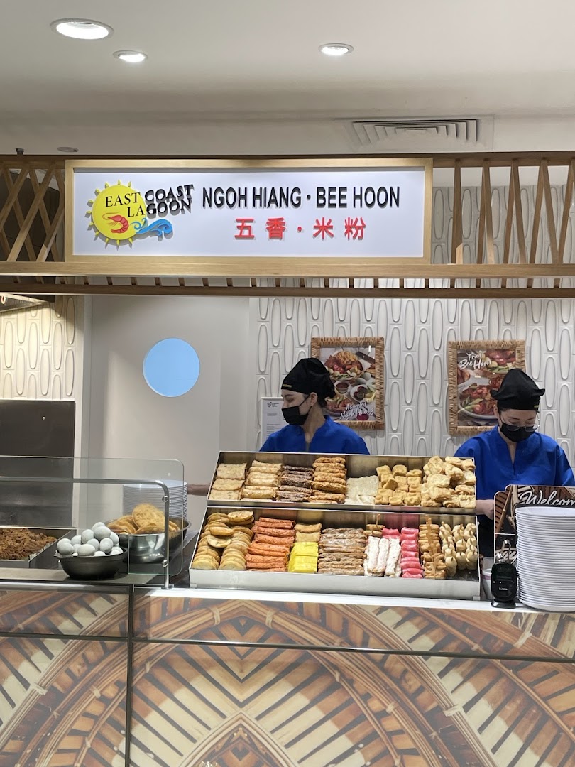 Two staff members behind a counter displaying a variety of Ngoh Hiang and Bee Hoon ingredients.