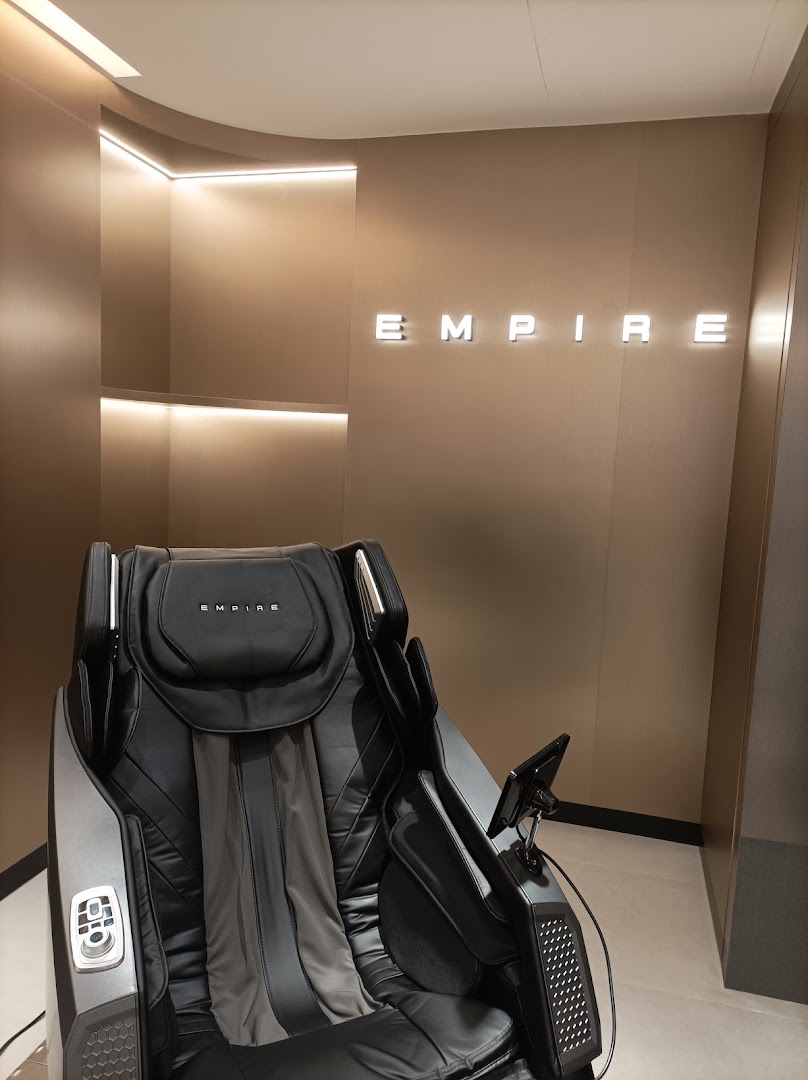 A luxurious black massage chair displayed inside the EMPIRE store, featuring modern design and ambient lighting.