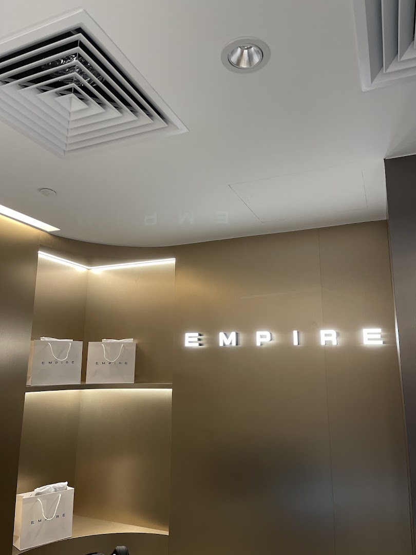 Interior shot of EMPIRE store featuring illuminated branding and display shelves with shopping bags.