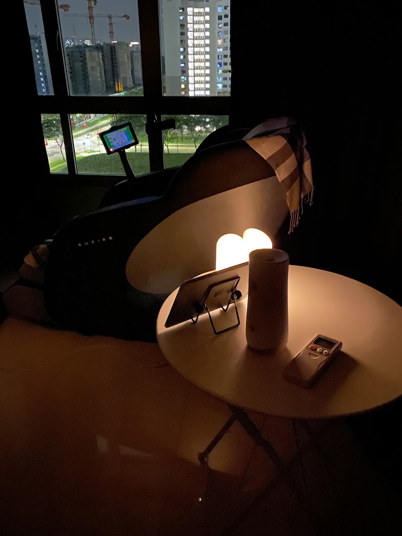 A luxurious massage chair illuminated in a cozy setting, offering relaxation with a city night view.