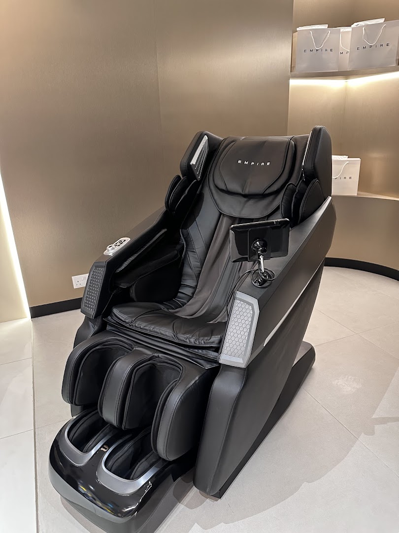 A sleek black EMPIRE massage chair is displayed in a modern retail setting.