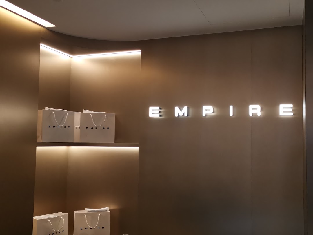 Interior shot of EMPIRE store featuring illuminated branding and display shelves with branded bags.