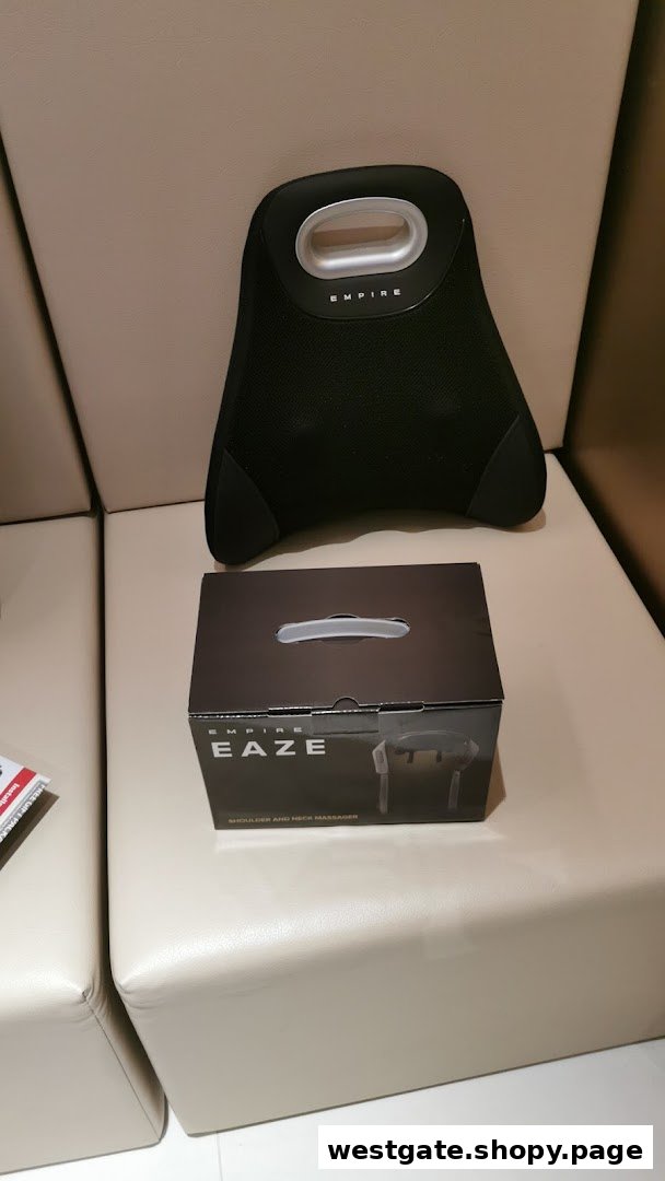 An Empire massage pillow and product box displayed on a light-colored sofa.