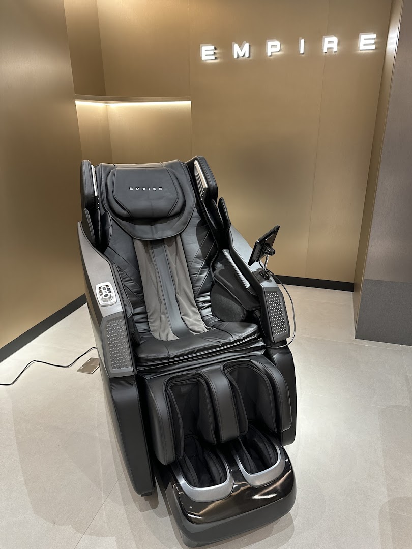 A sleek black Empire massage chair displayed in a modern retail setting.
