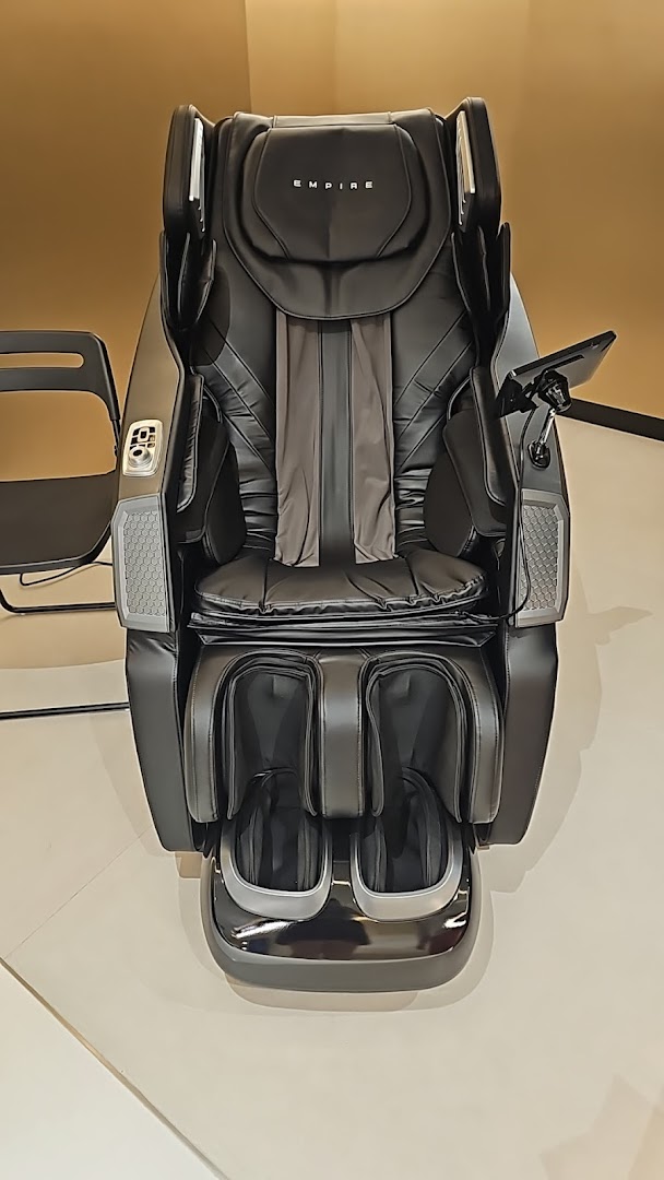 A luxurious black massage chair with the 'EMPIRE' logo on display.