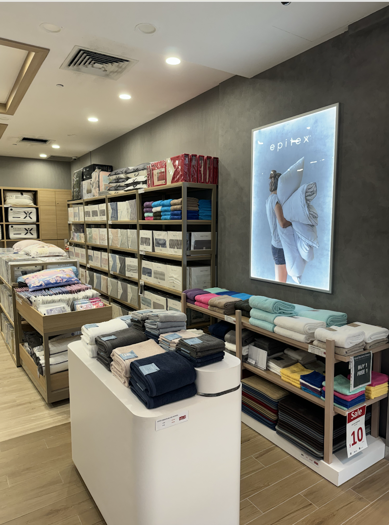An interior view of Epitex, showcasing a wide range of bedding, pillows, and towels on display.