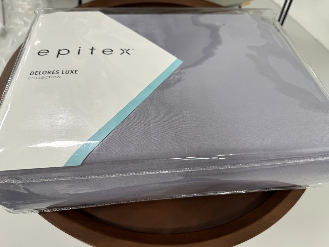 A packaged Epitex 'Delores Luxe Collection' bedding set in a soft grey color.