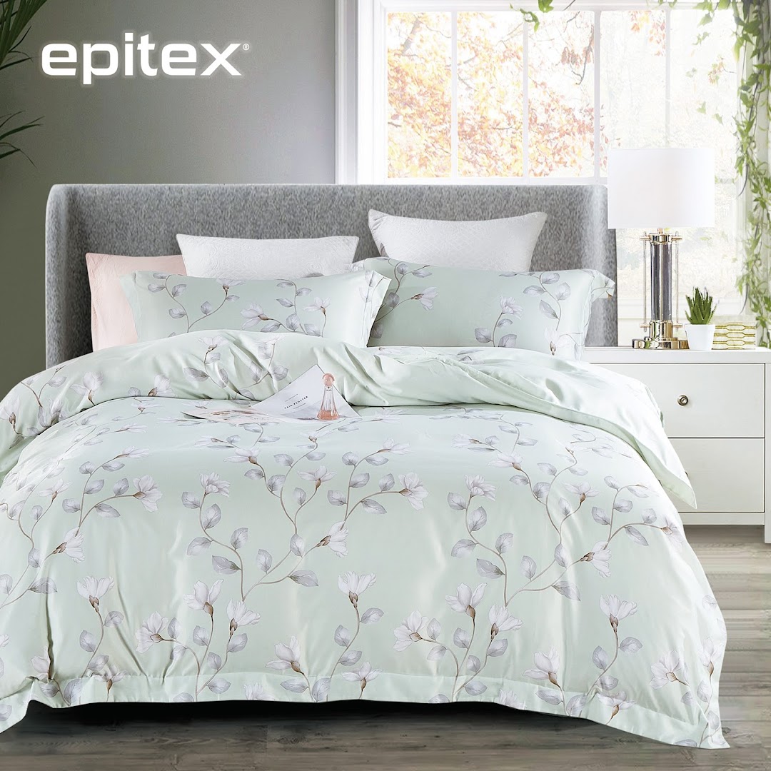 A beautifully made bed featuring light green floral bedding from Epitex, set in a bright bedroom.