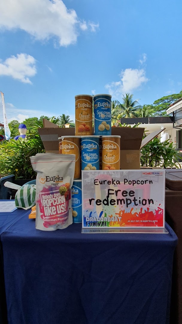 A display of Eureka Popcorn products on a table with a sign for free redemption.
