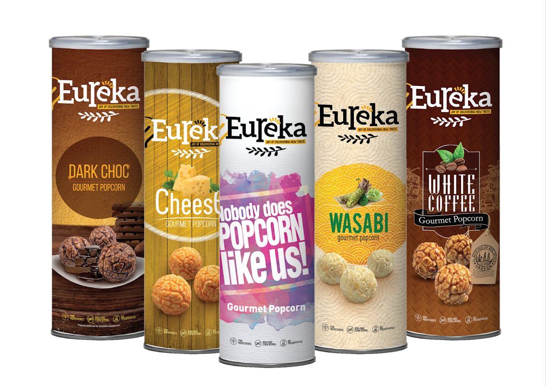 A vibrant display of Eureka Popcorn's gourmet popcorn cans in various flavors.