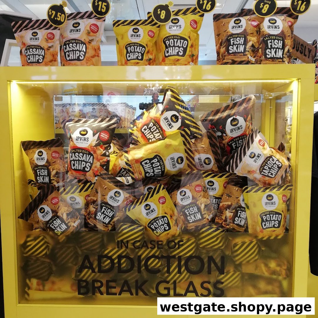 A vibrant yellow display case showcasing various Irvins Salted Egg snacks, including chips and fish skin.