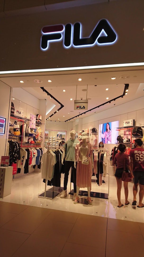 The image shows the brightly lit entrance of a FILA store with mannequins displaying sportswear and accessories.