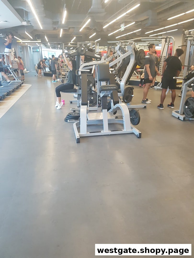 An active gym interior with members utilizing various weight training and cardio equipment.