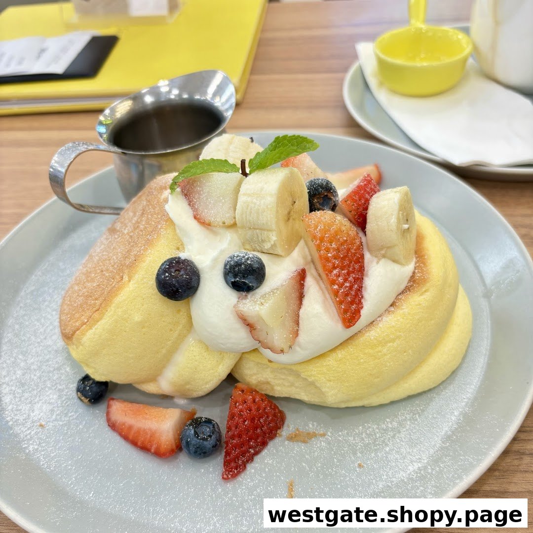 Fluffy soufflé pancakes with fresh berries, banana, whipped cream, and powdered sugar.