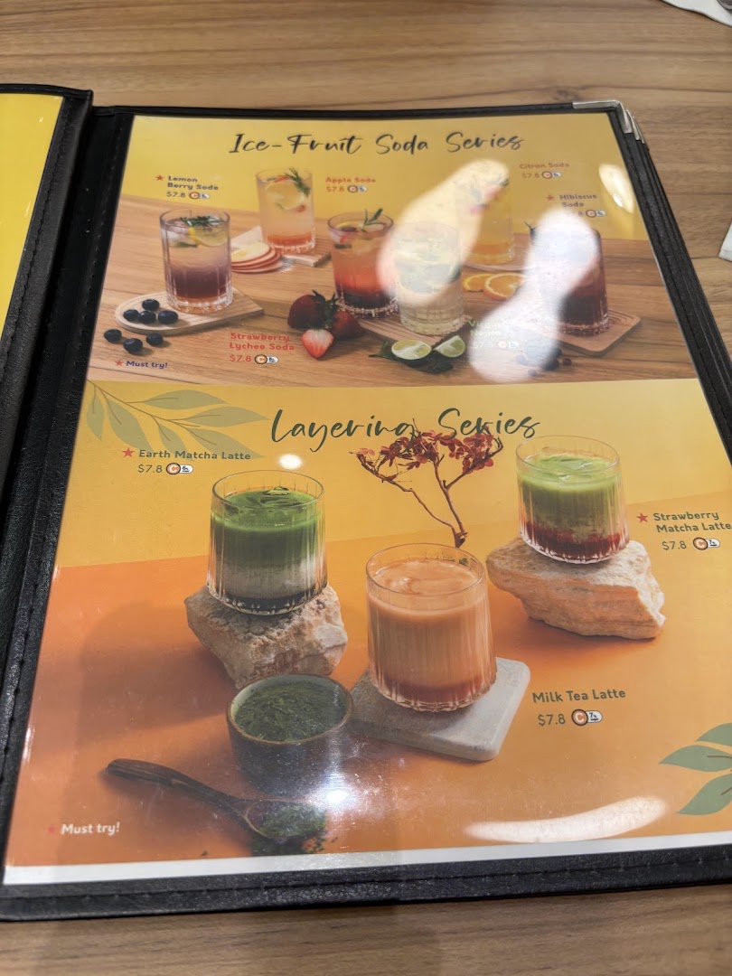 A vibrant menu page showcasing refreshing ice-fruit sodas and layered lattes with prices.