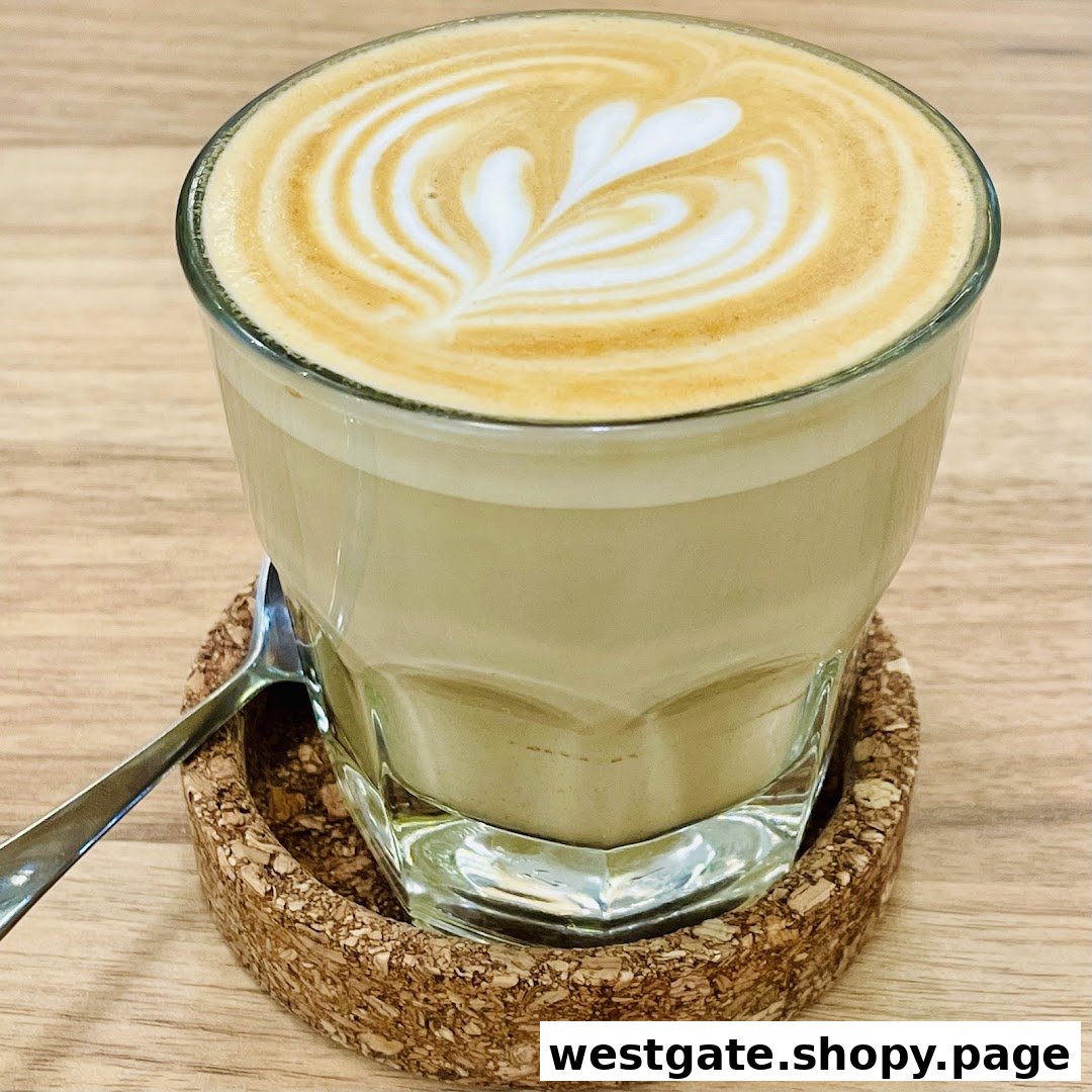 A close-up of a beautifully crafted latte with heart-shaped latte art on a cork coaster.