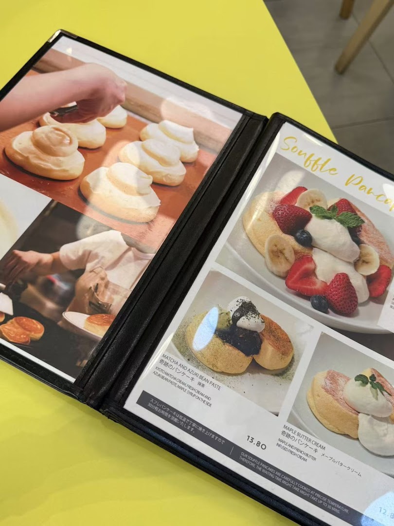 A menu displaying various fluffy souffle pancakes with different toppings and prices.