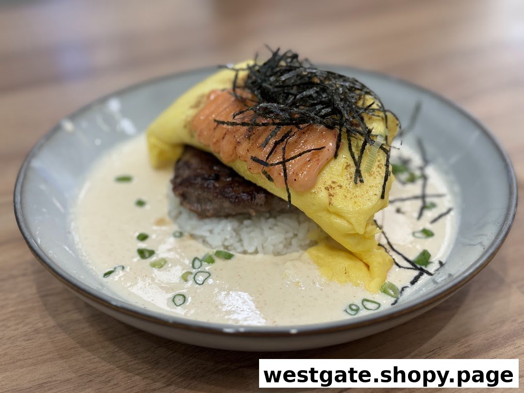 A close-up of a savory dish featuring an omelet, patty, rice, creamy sauce, and seaweed.