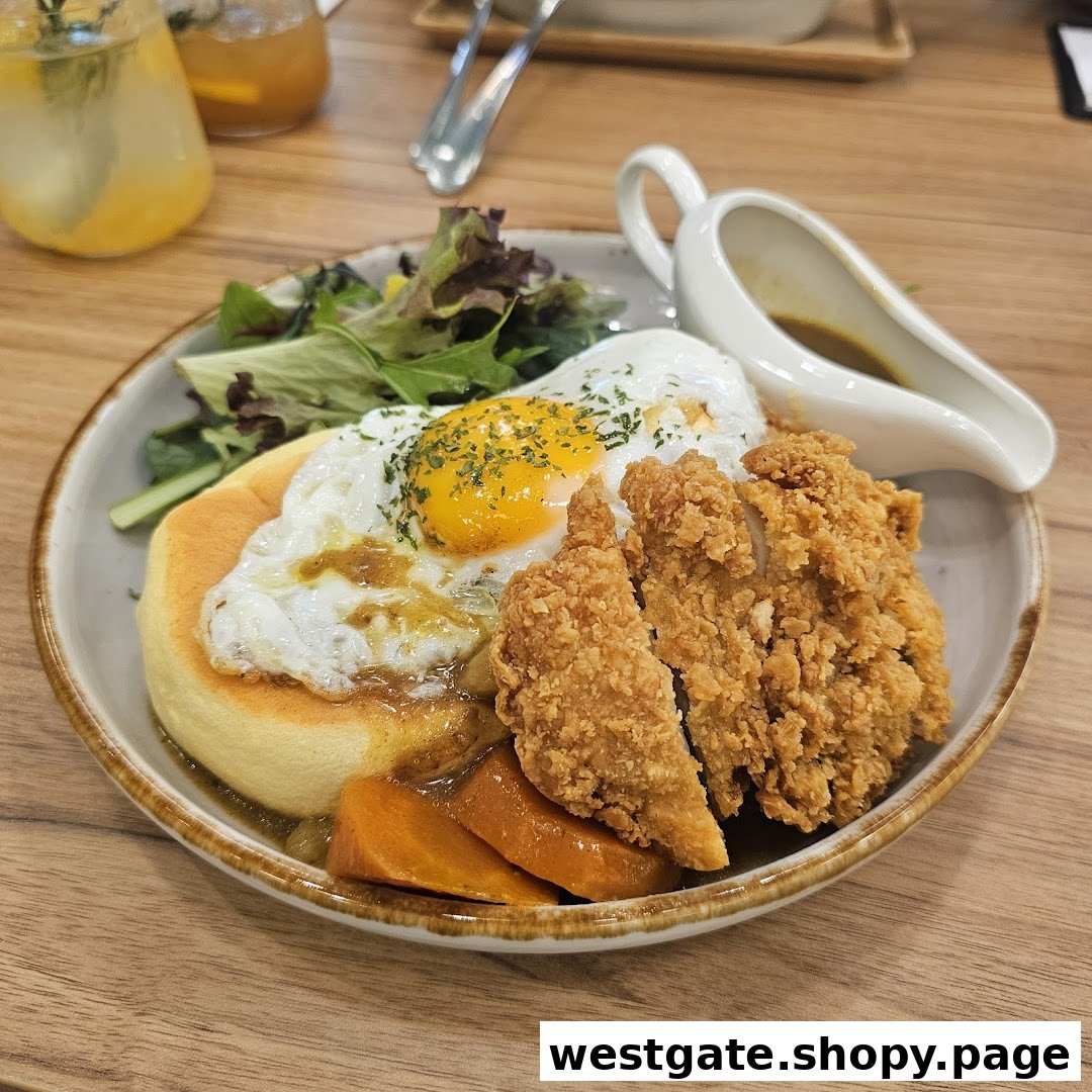 A delicious plate featuring crispy fried chicken, a fluffy pancake, fried egg, and curry sauce with vegetables.