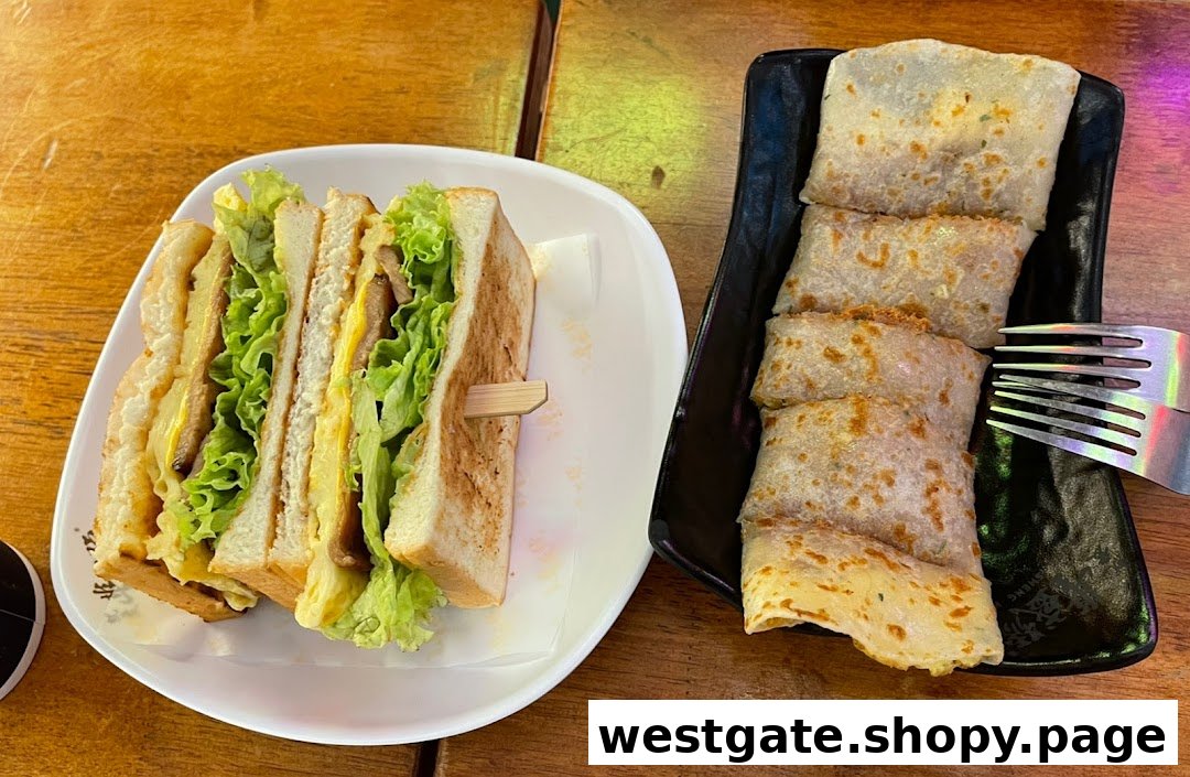 A delicious club sandwich and savory Taiwanese egg crepes on a wooden table.