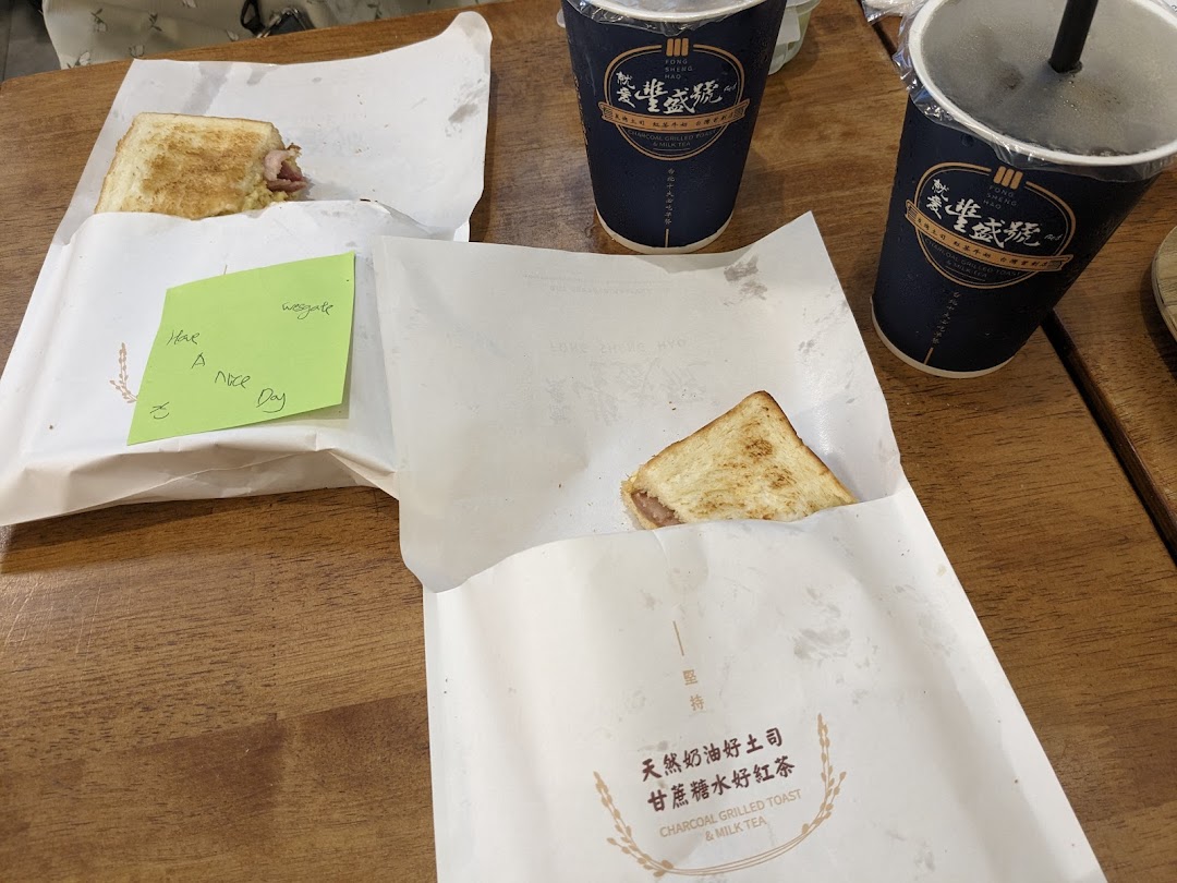 Two charcoal-grilled toasts and two milk tea drinks served on a wooden table.