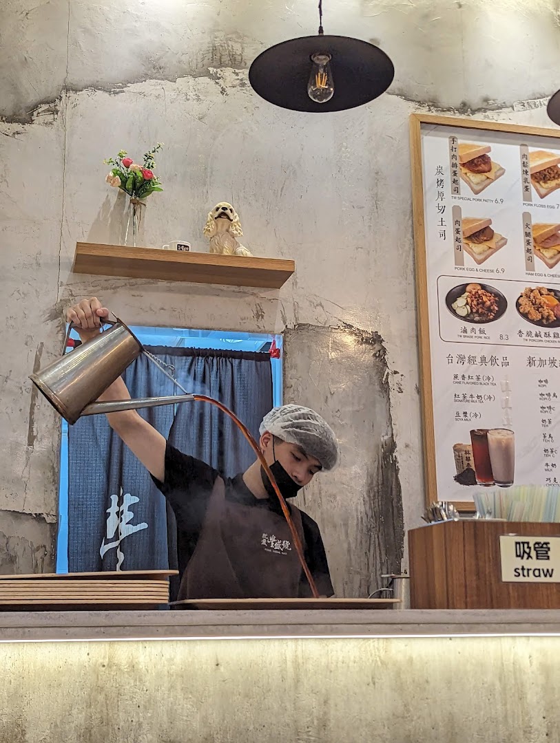 A staff member expertly prepares a drink behind the counter, with a menu board visible.