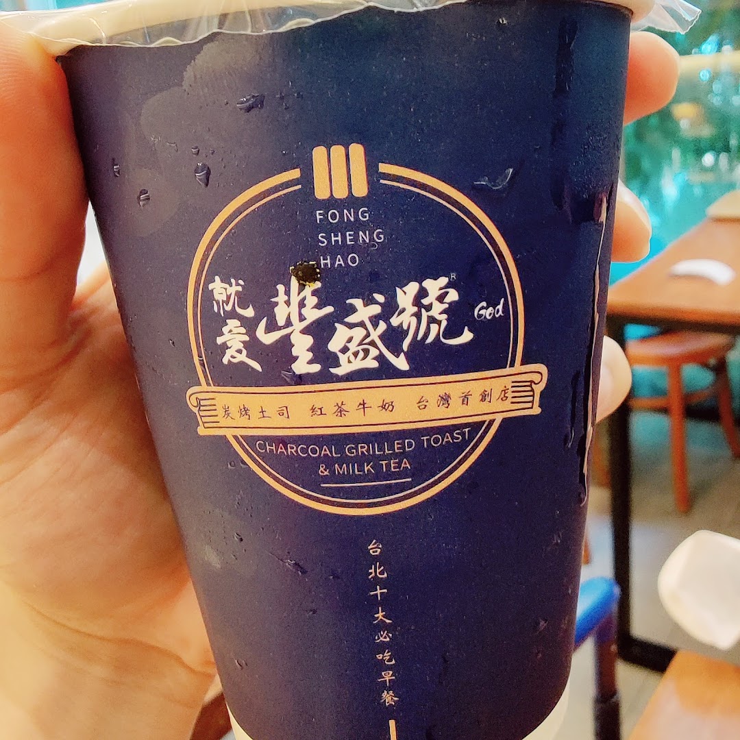 A hand holds a refreshing milk tea cup from Fong Sheng Hao, featuring its distinctive logo.