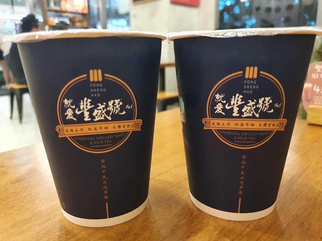Two branded cups from Fong Sheng Hao featuring their signature Charcoal Grilled Toast & Milk Tea.