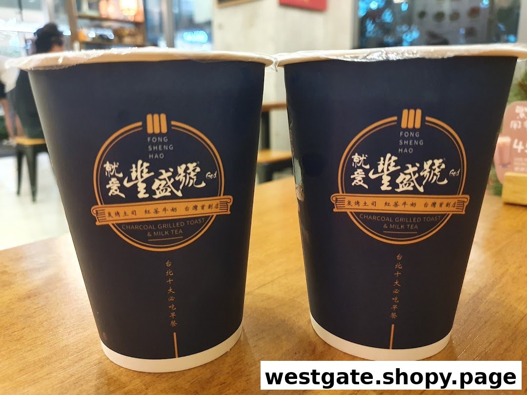 Two branded cups from Fong Sheng Hao featuring their signature Charcoal Grilled Toast & Milk Tea.
