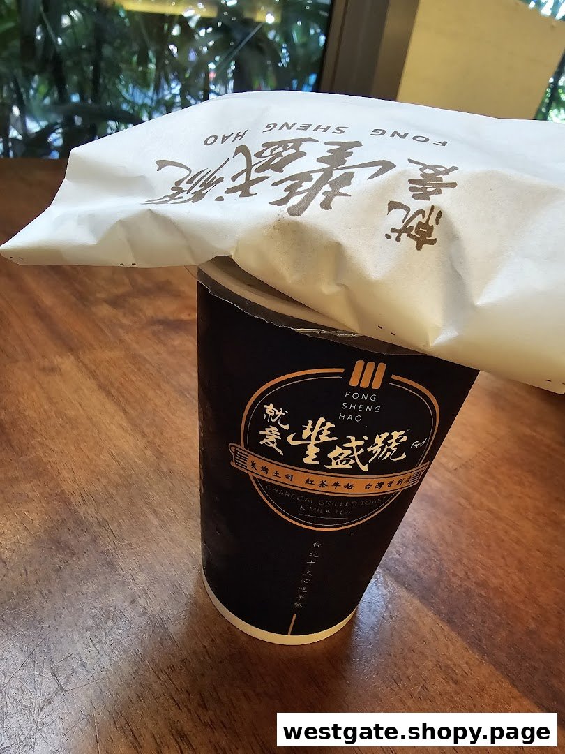 A branded drink cup and paper bag from Fong Sheng Hao on a wooden table.