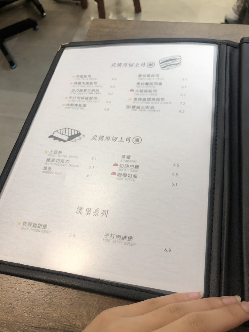 A close-up view of a menu displaying toast, burger, and sweet toast options.