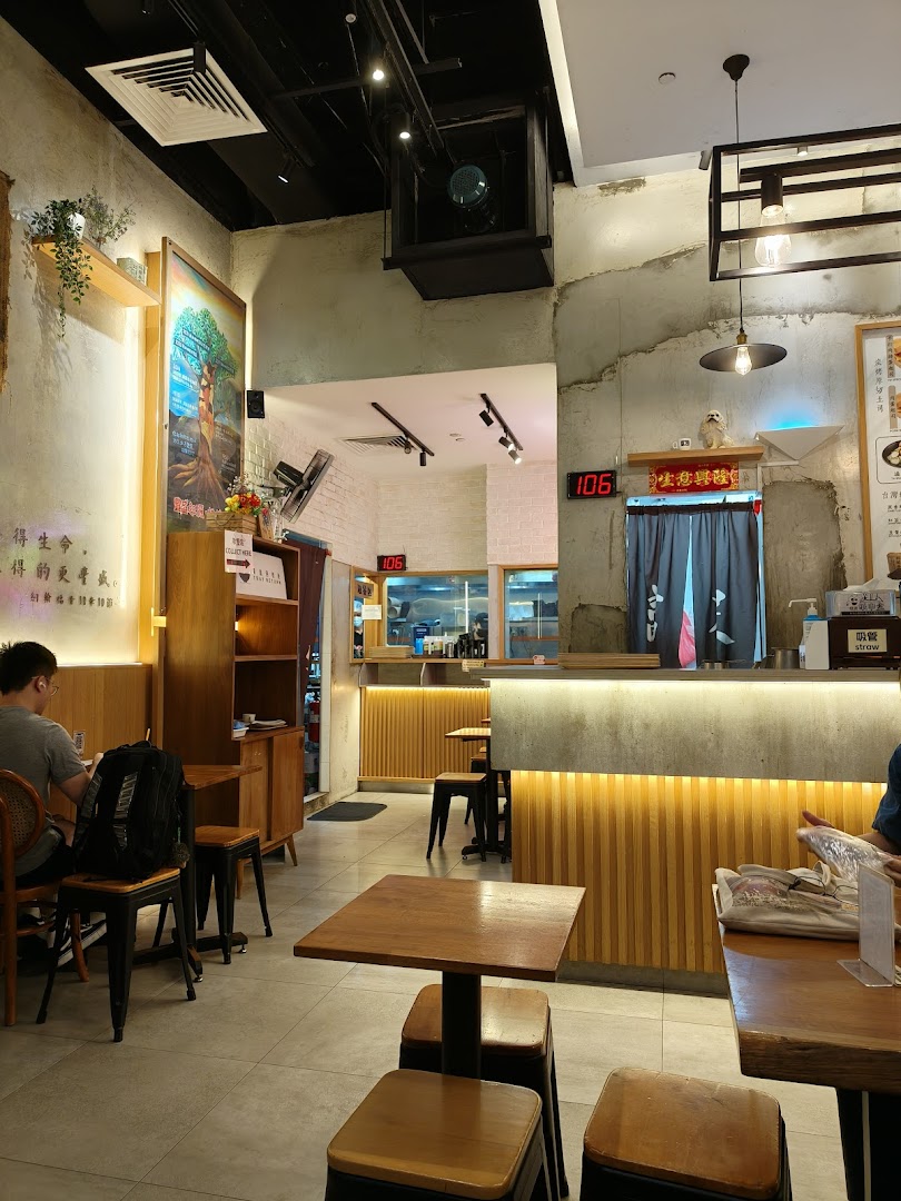 An inviting interior view of Fong Sheng Hao with wooden tables, concrete accents, and warm lighting.