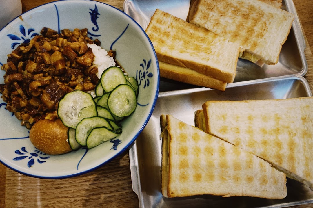 A delicious Taiwanese braised pork rice bowl with cucumber and egg, alongside toasted sandwiches.