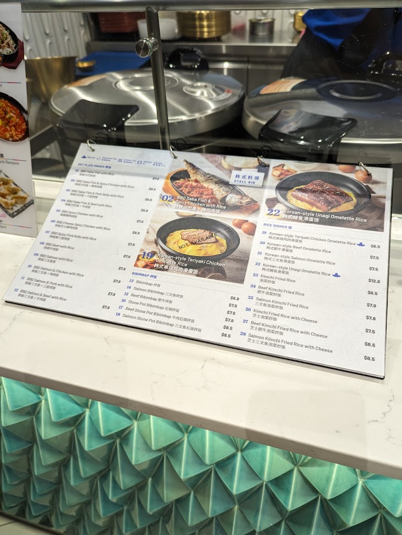 A detailed menu board displaying various Korean hot plate dishes, bibimbap, and rice dishes with prices.