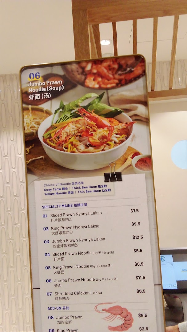 A vibrant menu board displaying various prawn and chicken noodle dishes with prices and noodle choices.