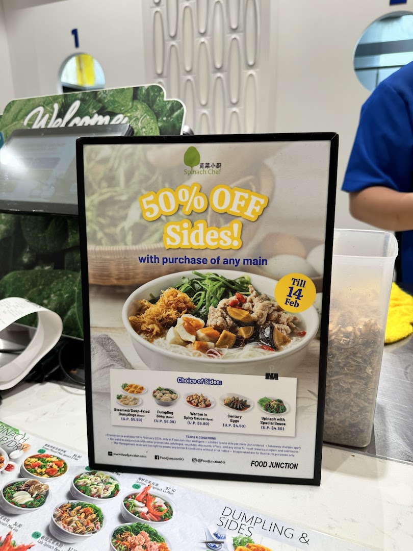 A promotional sign for Spinach Chef at Food Junction, offering 50% off sides with a main purchase.