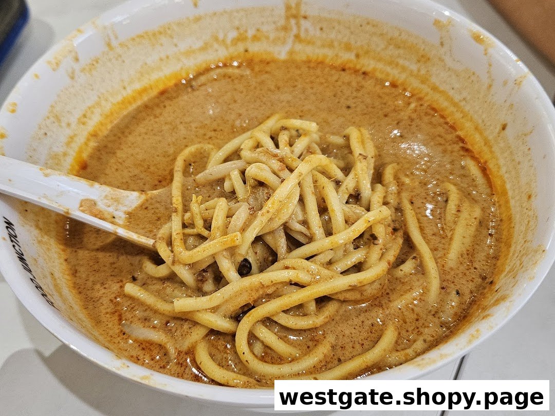 A close-up of a delicious bowl of curry noodles or laksa with a spoon.