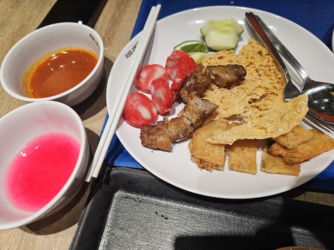 A plate of diverse fried snacks and dipping sauces from Food Junction.