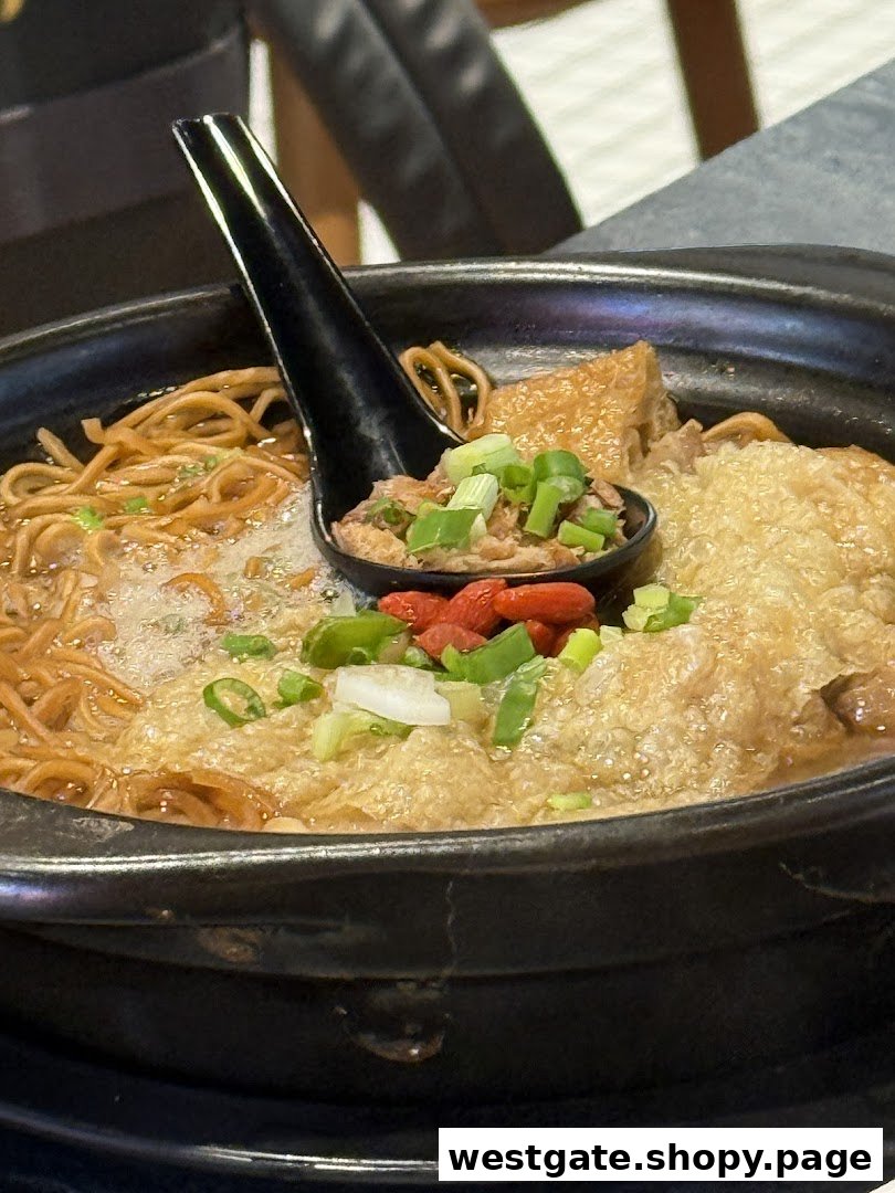 A close-up of a steaming bowl of noodles with various toppings and a spoon.