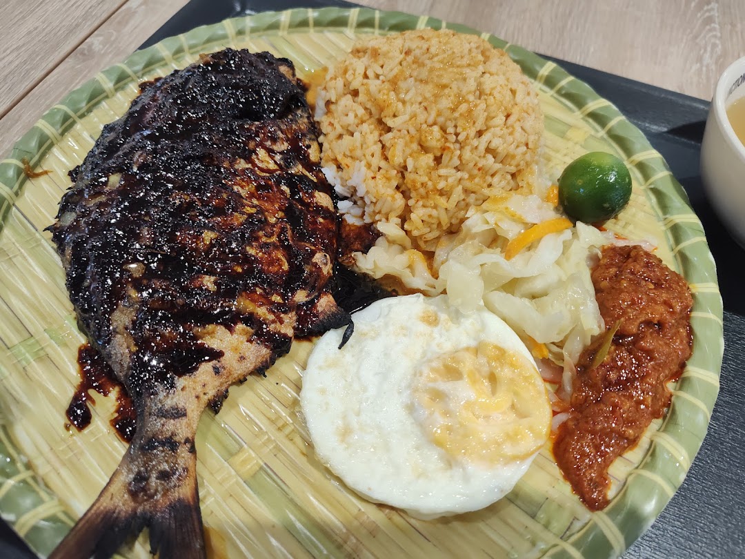 A delicious plate featuring grilled fish, spiced rice, fried egg, and sambal.