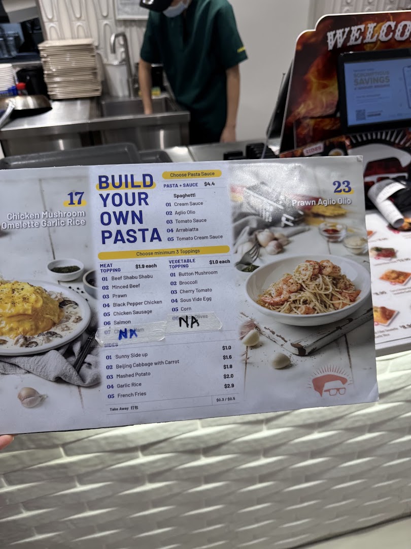 A close-up of a 'Build Your Own Pasta' menu with various options and prices, at a food stall.