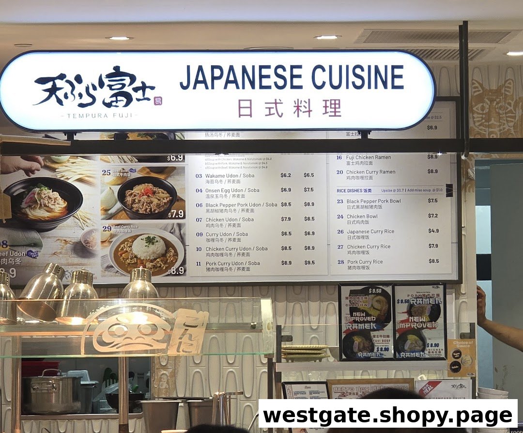 A Japanese cuisine stall's menu board displaying various udon, soba, ramen, and rice dishes.