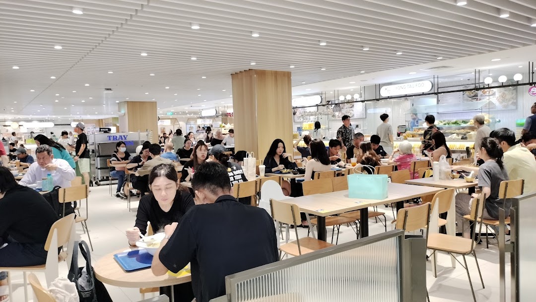 A bustling food court scene at Food Junction, filled with diners enjoying various meals.
