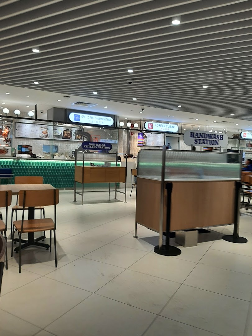 A spacious and modern food court interior with various food stalls and dining areas.