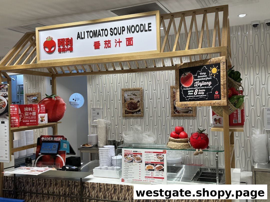 A vibrant food stall, Ali Tomato Soup Noodle, featuring a counter, signage, and tomato-themed decor.