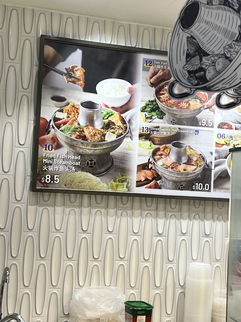 A close-up of a menu board displaying various steamboat dishes with prices at Food Junction.