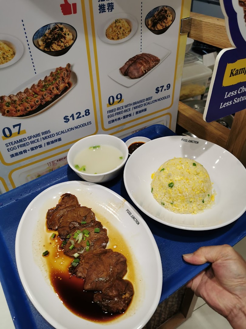 A delicious meal of braised beef and fried rice served on a tray with a menu display.