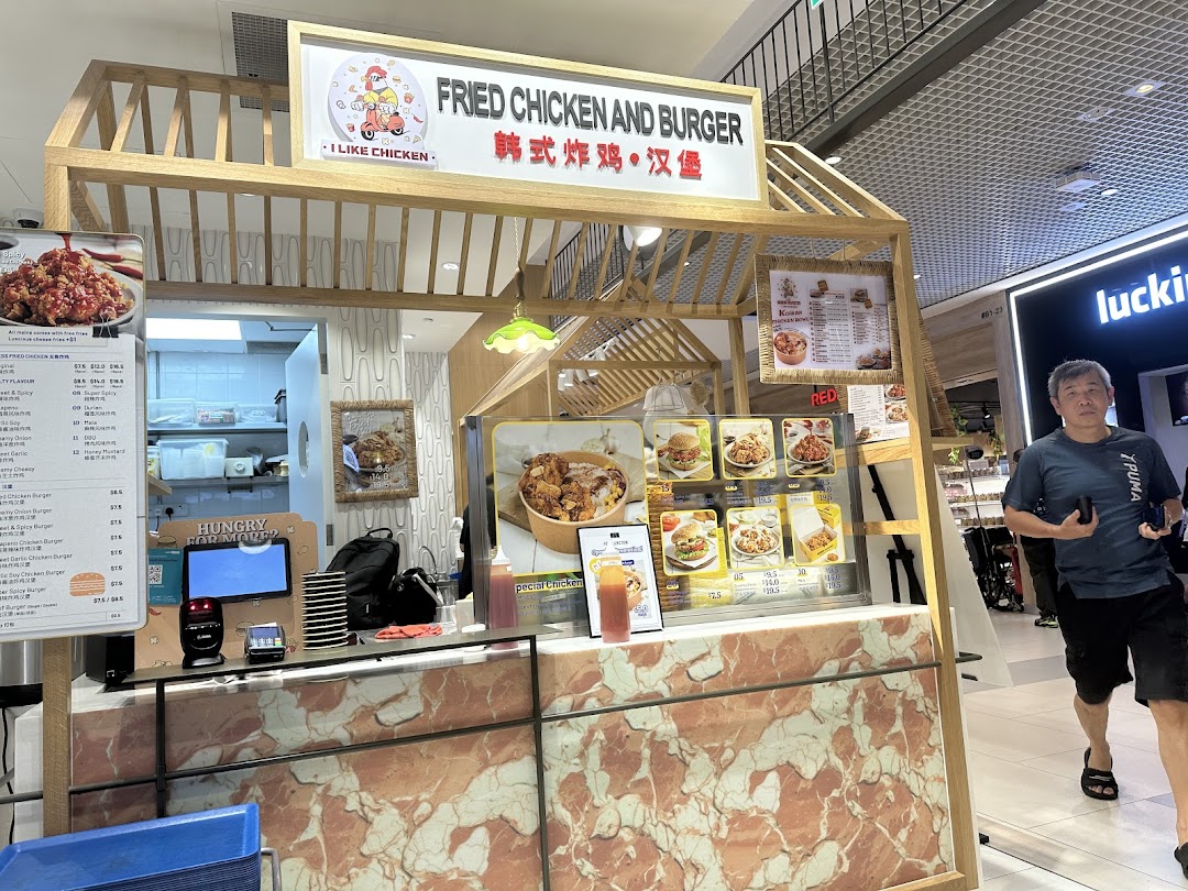 A bustling food stall named 'I Like Chicken' offering fried chicken and burgers.
