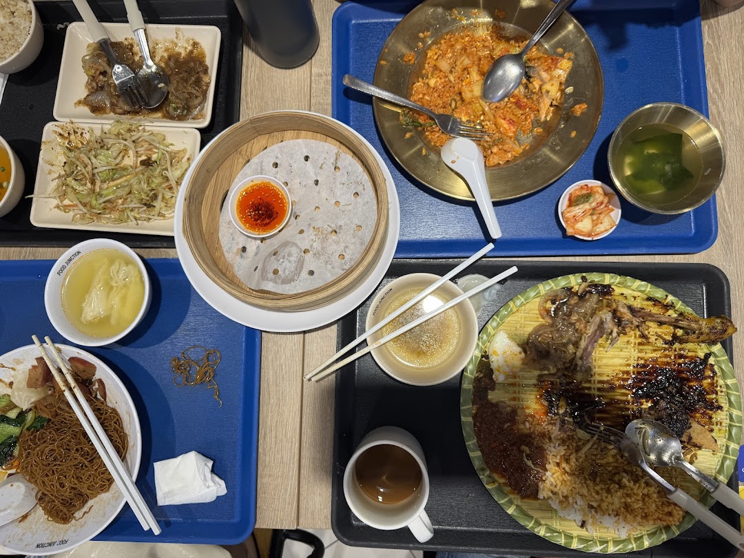 A table filled with various partially eaten Asian dishes, drinks, and cutlery on trays.