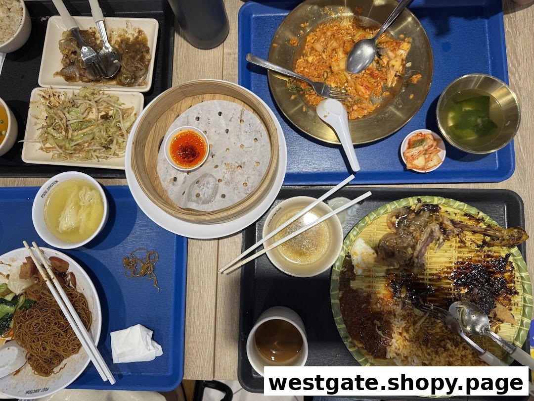 A table filled with various partially eaten Asian dishes, drinks, and cutlery on trays.